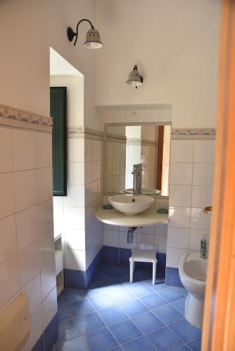 a bathroom with a sink and a toilet and a mirror at MEITHRAS holiday homes in Agrigento