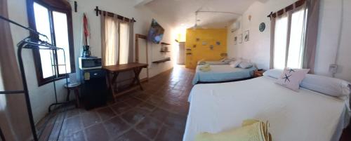 a room with two beds and a desk in it at Hotel Quinto Sol in Mazunte