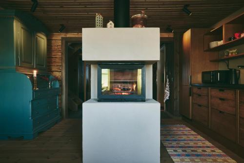 a living room with a fireplace in a kitchen at Lillstugan in Åre