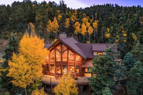 a large wooden house in the middle of a forest at Secluded Angel Fire Retreat Deck and Stunning View! in Angel Fire