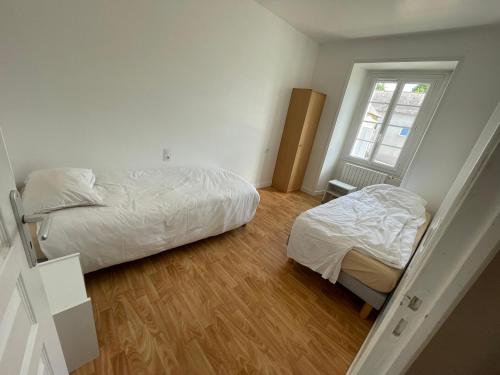 una camera da letto con due letti e una finestra di Gite proche Chateau-gontier a Marigné-Peuton
