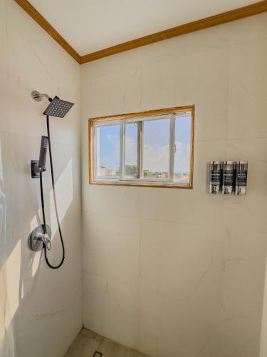 a shower in a bathroom with a window at Khepri Soleil Suite - 12min from UVF Airport in Vieux Fort