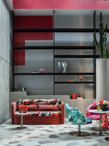 a living room with a red couch and two tables at Adge Hotel and Residences in Sydney