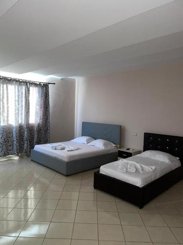 two beds sitting in a room with at Bar Hotel Orgito in Lushnjë