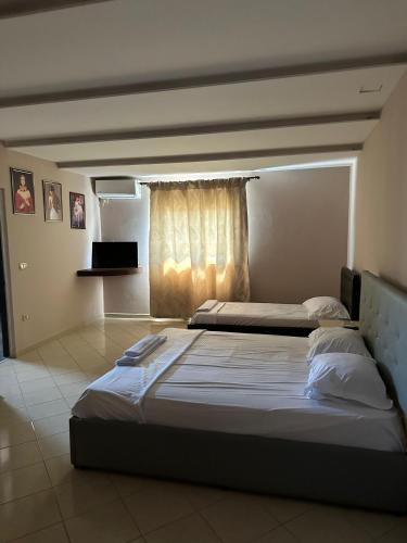 a bedroom with two beds and a window at Bar Hotel Orgito in Lushnjë