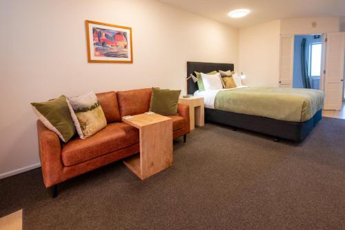 a bedroom with a bed and a couch and a bed at Tussock Peak Lodge in Hanmer Springs