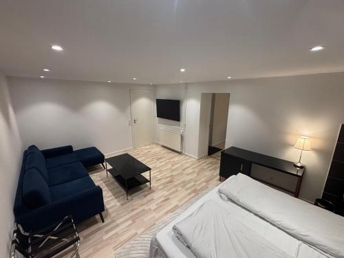 a bedroom with a bed and a couch and a television at Nordnest, 6 min from Airport in Copenhagen