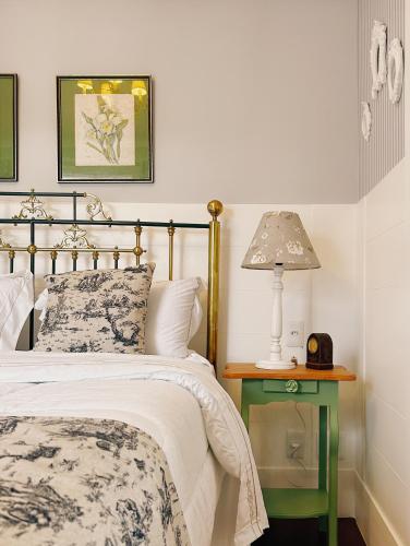 a bedroom with a bed and a table with a lamp at La Belle Provence in Itaipava