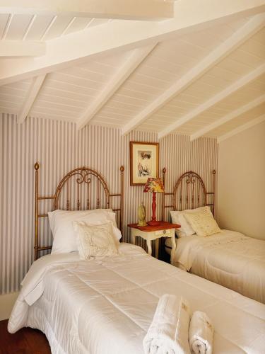 two beds in a room with striped walls at La Belle Provence in Itaipava