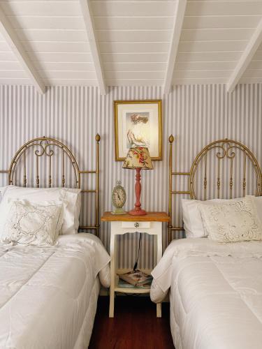 a bedroom with two beds and a table with a lamp at La Belle Provence in Itaipava