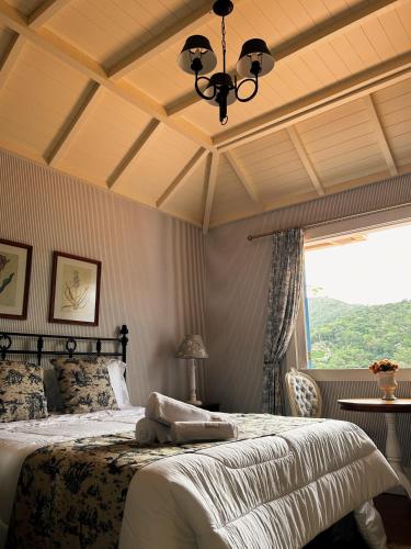 a bedroom with a bed and a large window at La Belle Provence in Itaipava