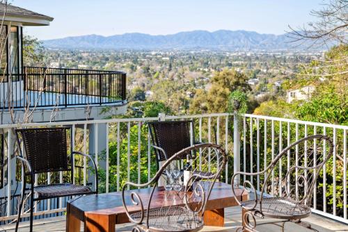 a table and chairs on a balcony with a view at Quiet Home with Spectacular Scenic Mountain Views near Universal Studios Hollywood in Los Angeles
