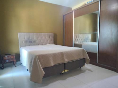 a bedroom with a bed and a large mirror at Casa INDEPENDENTE 4 QUARTOS VILA DO PERÓ CABO FRIO in Cabo Frio