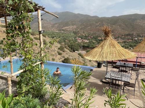 a man in the swimming pool at a resort at Ouirgane discovery lodge in Ouirgane