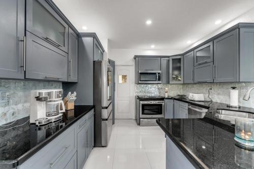 a kitchen with white appliances and black cabinets at The Lake house 305 , Perfect Sunset in Tamiami