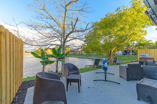 a patio with chairs and tables and a body of water at The Lake house 305 , Perfect Sunset in Tamiami