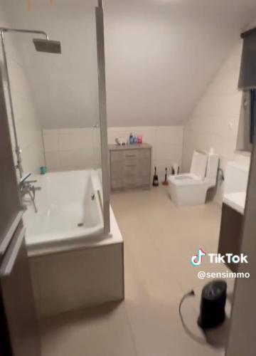 a bathroom with a sink and a tub and a toilet at Duplex appartement met 3 slaapkamers in Genk