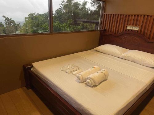a bed with two rolled up towels on it at AVEYA Staycation in Tanay