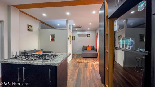 a kitchen with a stove and a living room at Villa Opulence - 12min from UVF Airport in Vieux Fort