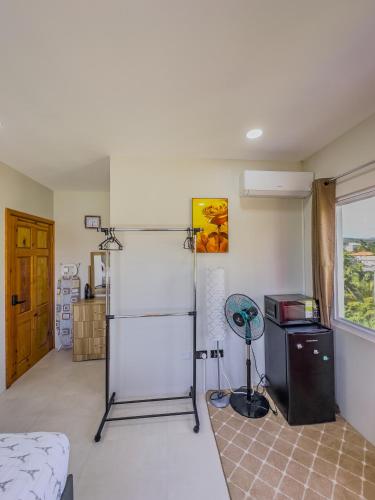 a room with a bed and a refrigerator and a window at Villa Opulence - 12min from UVF Airport in Vieux Fort