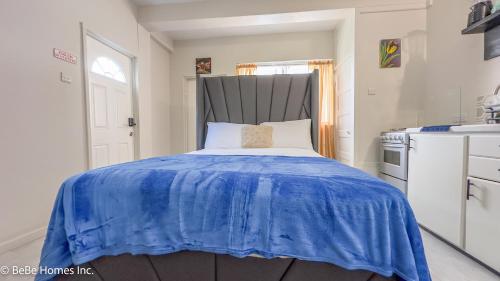 a bedroom with a bed with a blue blanket on it at Villa Opulence - 12min from UVF Airport in Vieux Fort