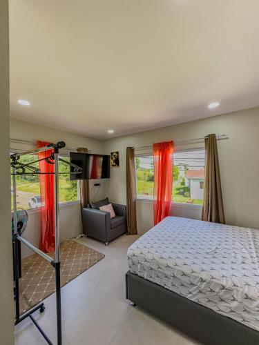a bedroom with a bed and a couch at Villa Opulence - 12min from UVF Airport in Vieux Fort