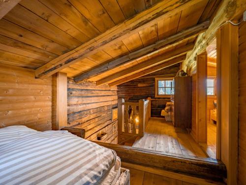 una camera con un letto in una baita di tronchi di EAGGA-Niederleger Alm ad Alpbach