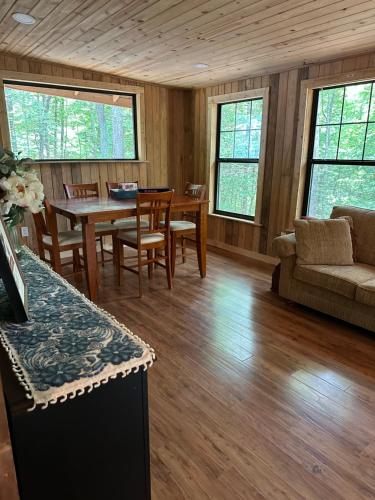 a living room with a table and a couch at Peaceful, cozy cabin in the woods in Murphy