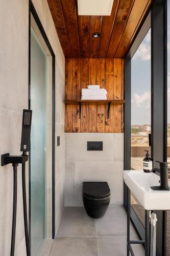 a bathroom with a toilet and a sink at Ghost House at Ghost Town Casitas in Terlingua