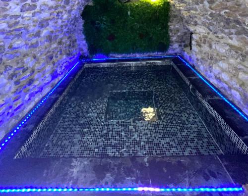 ein leeres Schwimmbecken mit blauen Lichtern auf dem Boden in der Unterkunft cottage cocon et loft in Villampuy