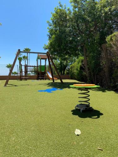 a park with a playground with a swing set at Benalmadena Suite Vistas panorámicas, 2 piscinas, Area infantil, Bar, Jardines y Tenis in Benalmádena
