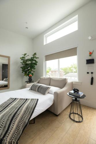 a white bedroom with a couch and a window at The Waypoint in Rehoboth Beach