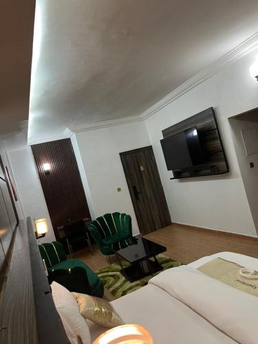 a hotel room with a bed and a flat screen tv at Amelia Aparthotel in Buea