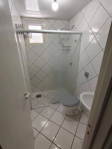 a white bathroom with a toilet and a sink at Studio Centro Floripa 02 in Florianópolis