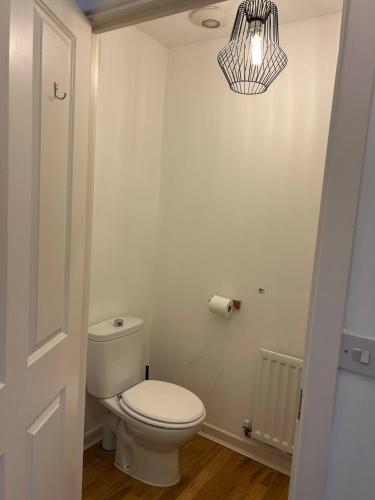 a bathroom with a white toilet and a chandelier at Stunning 2BR house in Colchester in Colchester