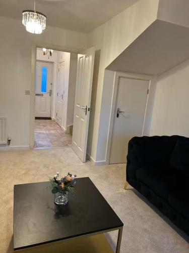 a living room with a black table and a black couch at Stunning 2BR house in Colchester in Colchester