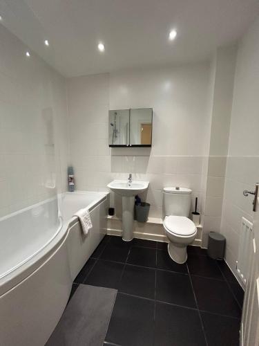 a bathroom with a sink and a toilet and a bath tub at Stunning 2BR house in Colchester in Colchester