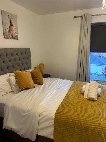 a bedroom with a large bed with yellow and white pillows at Stunning 2BR house in Colchester in Colchester