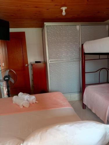 a bedroom with two beds with a stuffed animal on the floor at Hotel El Balcon de madera in Norcasia