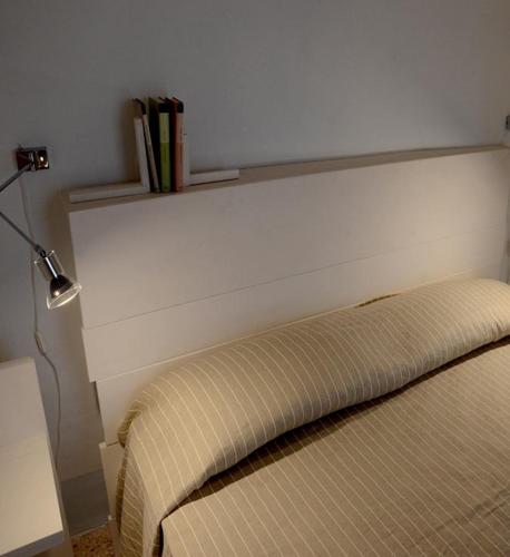 a bedroom with a bed with a headboard and a lamp at Rosa dei Venti in Tricase