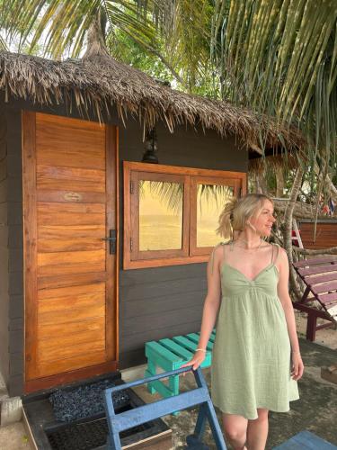 a woman in a green dress standing in front of a house at Tomorrowland Beach Villas in Tangalle