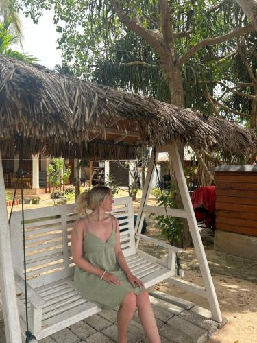 a woman in a green dress sitting on a chair at Tomorrowland Beach Villas in Tangalle