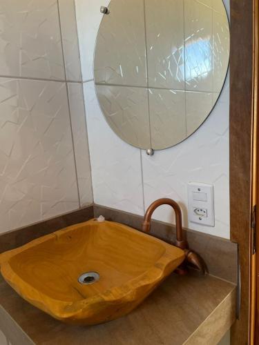 a wooden sink in a bathroom with a mirror at Hotel Fazenda Brisa dos Gerais in Palmeiras