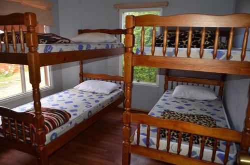 two bunk beds in a room with a window at Hostel Patagonia Backpackers in Puerto Natales