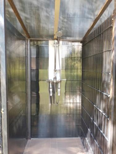 a shower in a room with a glass door at Camping -Dor de Munte -Ceahlau in Bistricioara