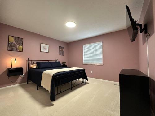 a bedroom with a bed and a television in it at Blessed Beyond Measure King with Ensuite in Norwalk