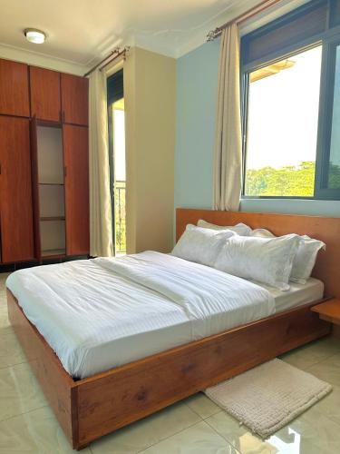 a bed in a bedroom with a large window at Lake view 2bedrooms 3 balconies WIFI Netflix 2bathroom 5mnts walk to the lake in Nalakonge