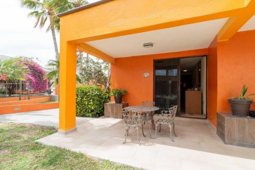 a patio with a table and chairs in front of a building at Hotel Playa Del Sol in Los Barriles