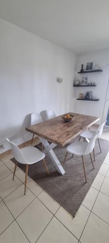 a wooden table with two white chairs around it at Sol & Lar No stress in Santa Maria