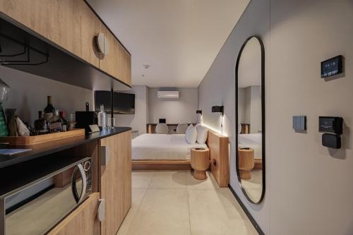 a bedroom with a bed and a bathroom with a mirror at Seissta Medellín in Medellín